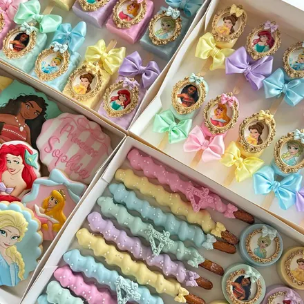 Large party package with Disney princess cameo chocolate-covered treats in pastel colors, each finished with a gold frame and satin bow.