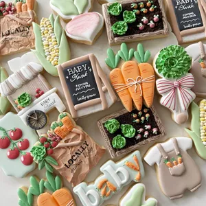 Farmers-market themed baby shower cookie set for "Baby Kwak" with carrots, corn, tomatoes, a garden crate, and chalkboard signs reading "Locally Grown" in sage green and terracotta.
